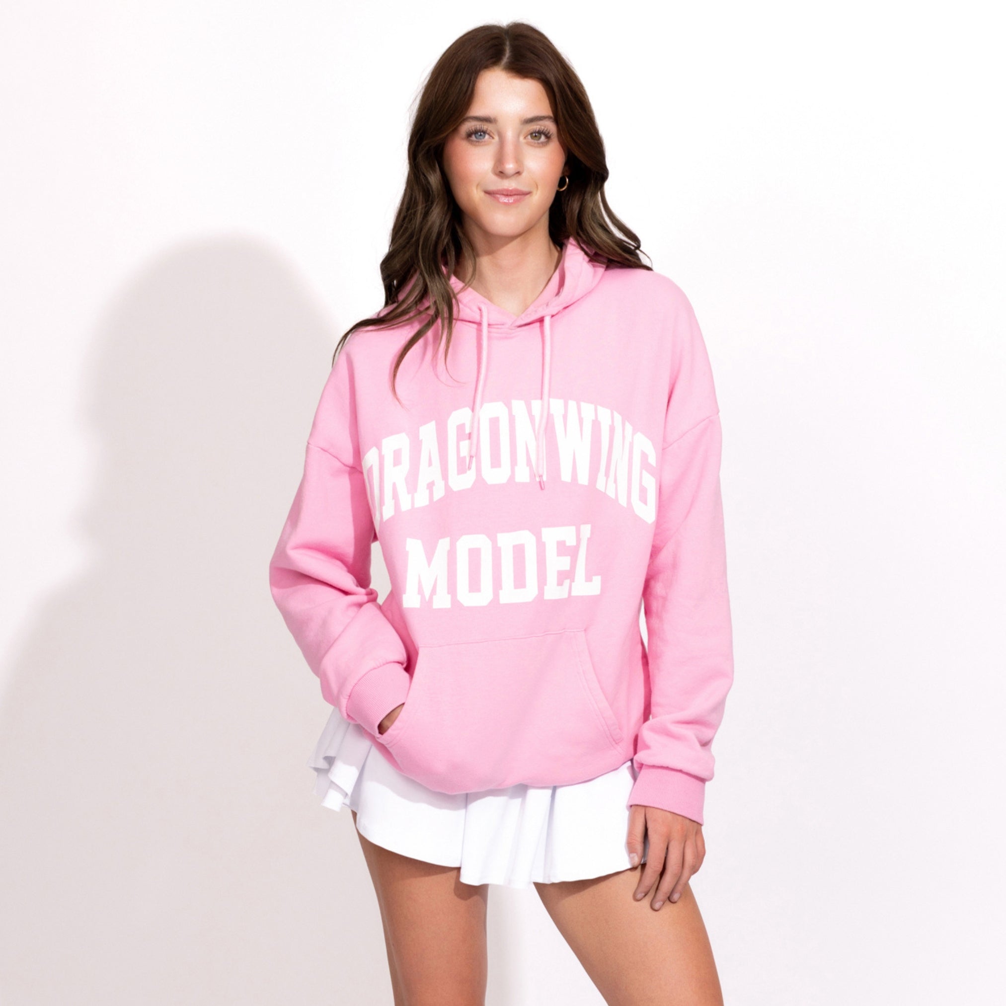 Person wearing a pink hoodie with 'Dragonwing Model' text on a white background