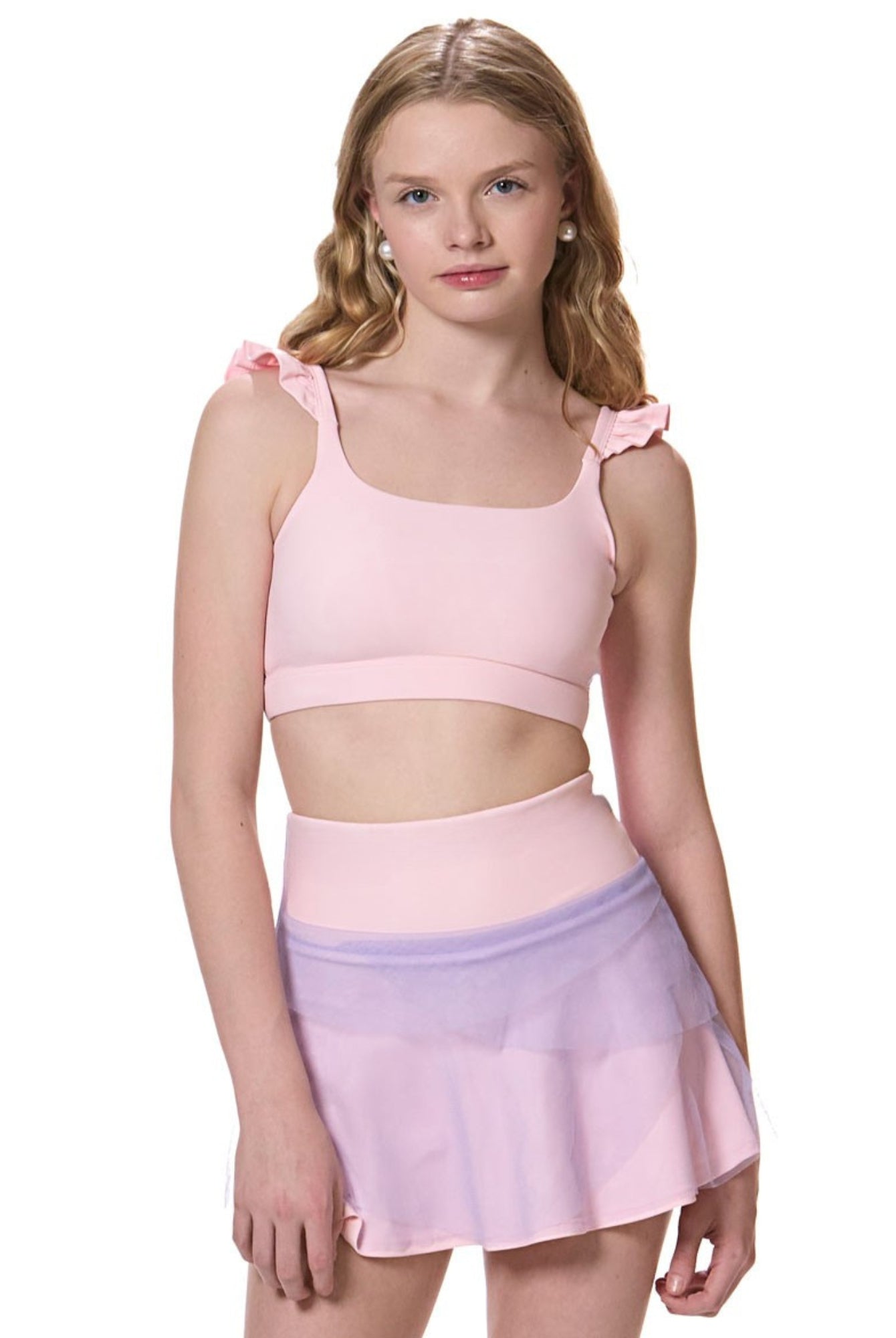 girl wearing flare tennis skirt with matching pink sports bra front view