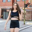 Woman in black athletic wear standing on a street with brick buildings in the background